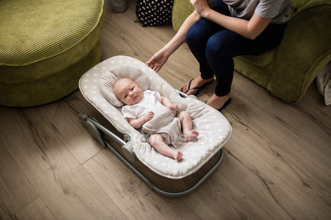 Cropped image of Mother taking care of her baby in living room at home — Stock Photo