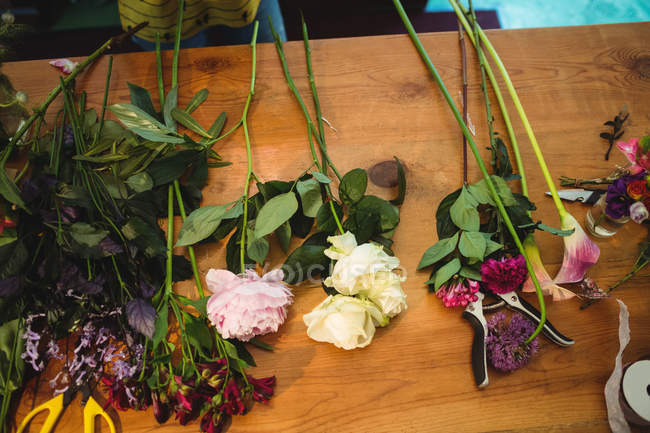 Primer plano de las flores en la mesa en la florería - foto de stock