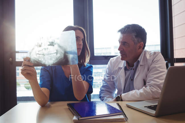 Médico y enfermera examinando rayos X en el hospital - foto de stock