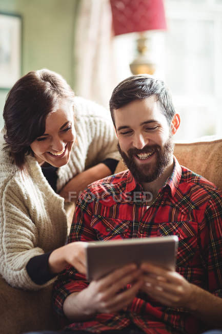 Coppia utilizzando tablet digitale in soggiorno a casa — Foto stock