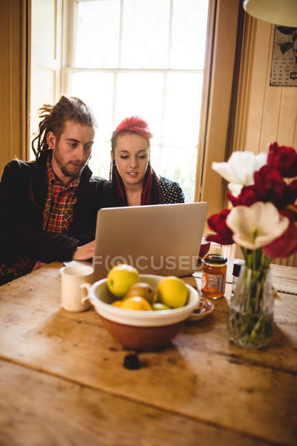 Молода пара дивиться на ноутбук на столі в будинку — стокове фото