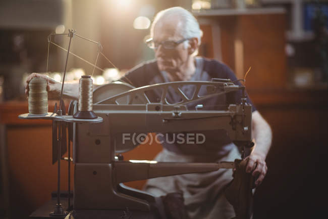 Чоботар, використовуючи швейні машини в майстерні — стокове фото