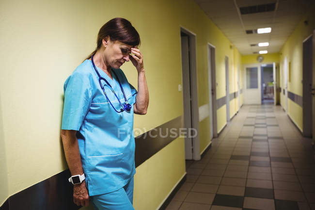 Депрессивная медсестра, стоящая в коридоре больницы — стоковое фото