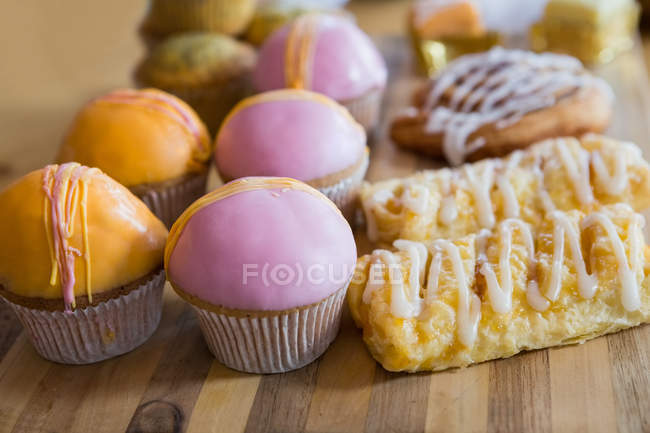 Close up of cupcakes on wooden tray in cafeteria — Stock Photo