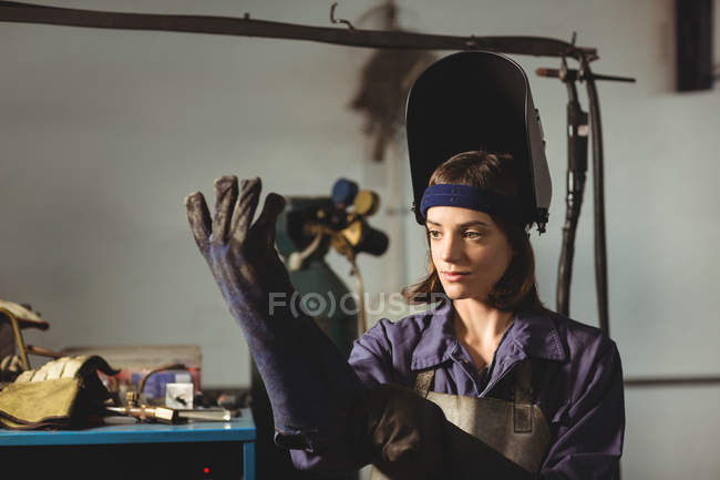 Жіноча зварювальна рукавичка в майстерні — стокове фото