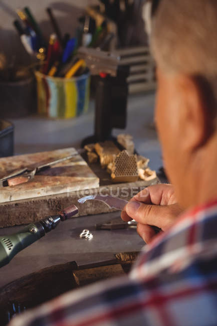 Goldsmith utilizando la máquina de piezas de mano en el taller - foto de stock
