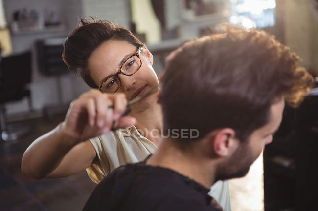 Homem recebendo seu cabelo aparado no salão de cabeleireiro — Fotografia de Stock