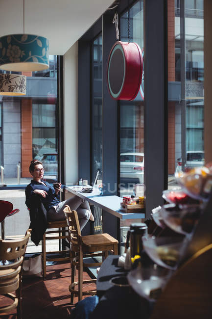 Jovem empresária sentada na cadeira no café — Fotografia de Stock