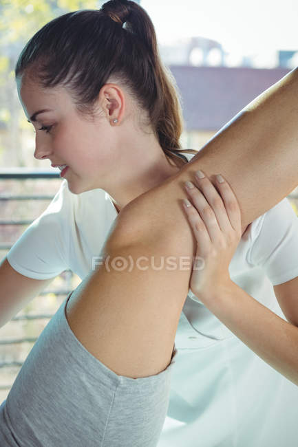 Fisioterapeuta dando fisioterapia para perna de paciente do sexo feminino na clínica — Fotografia de Stock