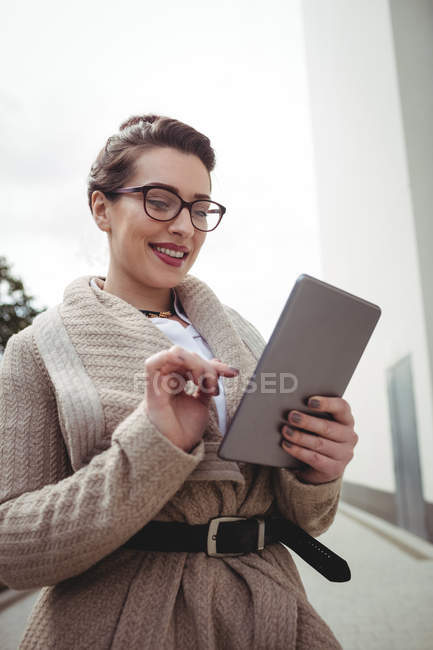 Молодая женщина использует цифровой планшет на тропинке — стоковое фото
