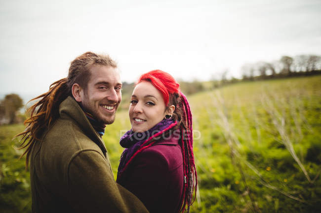Retrato de casal hipster sorridente em pé no parque — Fotografia de Stock