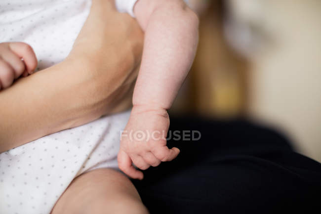 Imagem cortada de mãe segurando bebê em casa — Fotografia de Stock