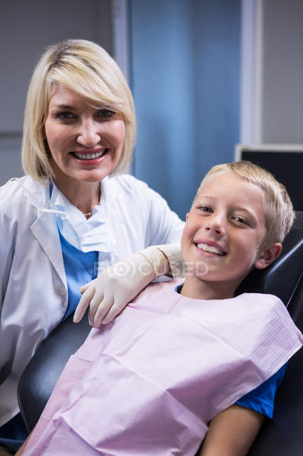 Портрет усміхненого стоматолога і молодого пацієнта в стоматологічній клініці — стокове фото