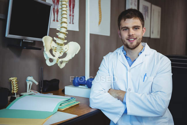 Портрет физиотерапевта, сидящего за столом в клинике — стоковое фото