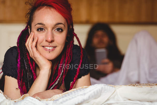 Portrait de jeune femme relaxant par l'homme sur le lit à la maison — Photo de stock