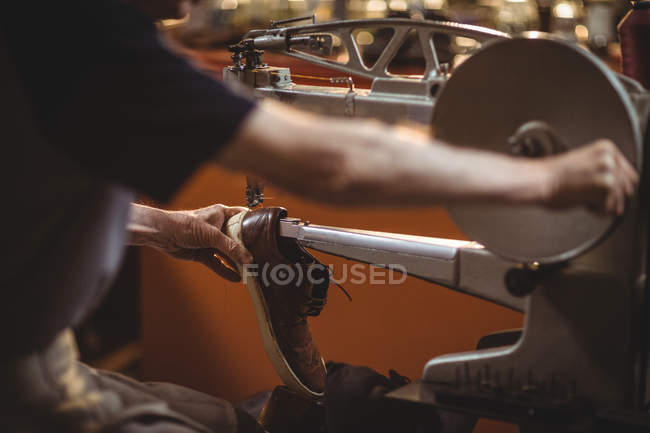 Mains de cordonnier utilisant une machine à coudre en atelier — Photo de stock