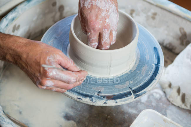 Primer plano de alfarero haciendo olla en taller de cerámica - foto de stock