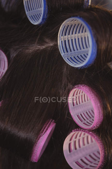 Image recadrée de Femme avec des rouleaux de cheveux bleus et roses au salon — Photo de stock