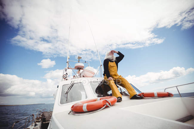 Рибалка сидить на палубі і дивиться — стокове фото