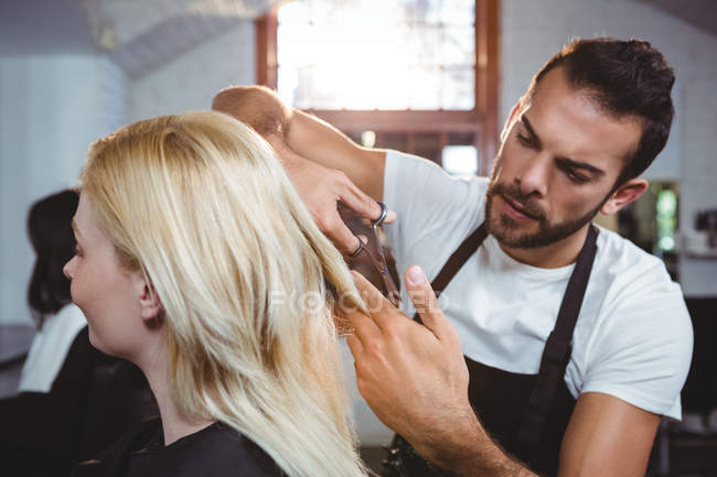 Feminino recebendo seu cabelo aparado com tesoura no salão — Fotografia de Stock