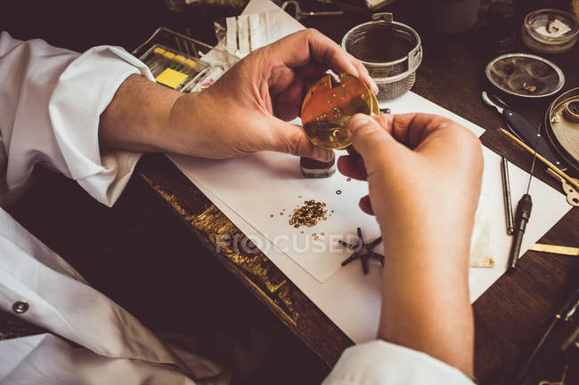 Hands of horologist repairing a watch in the workshop — Stock Photo