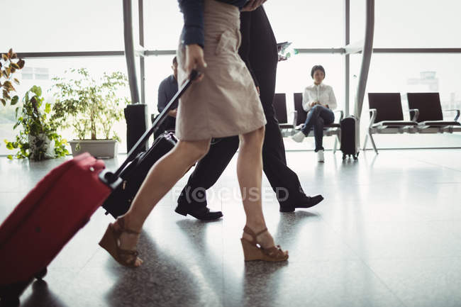 Business people walking with luggage in airport terminal — Stock Photo