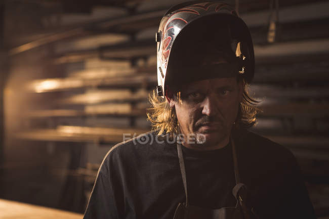 Портрет кузнеца в защитном шлеме в мастерской — стоковое фото