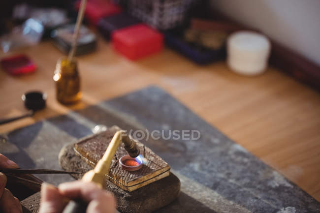 Abgeschnittenes Bild eines Goldschmiedrings mit dem Brenner in der Werkstatt — Stockfoto