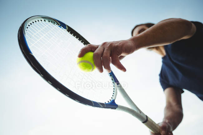 Low angle view of man with tennis racket ready to serving in court — Stock Photo