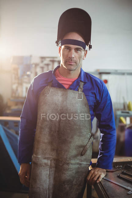Retrato de soldador masculino de pie en el taller y mirando a la cámara - foto de stock