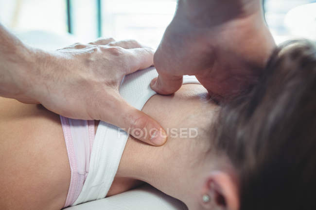 Physiotherapist giving physical therapy to neck of female patient in clinic — Stock Photo
