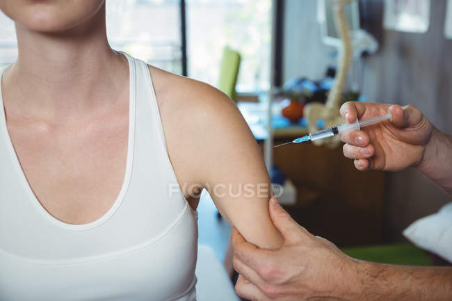 Imagem recortada do terapeuta masculino injetando paciente feminino na clínica — Fotografia de Stock