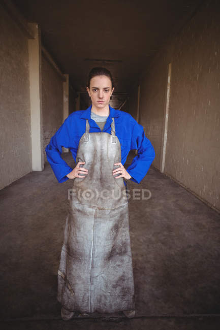 Retrato de soldador fêmea em pé com as mãos nos quadris no corredor — Fotografia de Stock