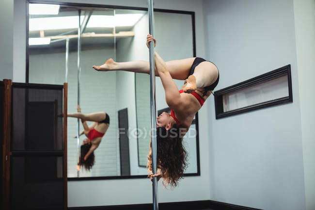 Танцовщица на шесте практикует танец в фитнес-студии — стоковое фото