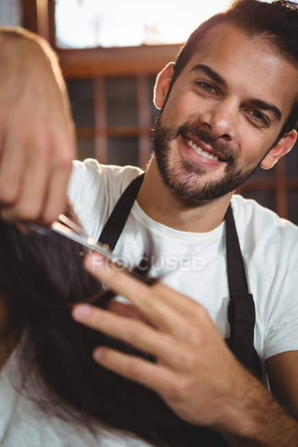 Female getting her hair trimmed with scissors in salon — Stock Photo