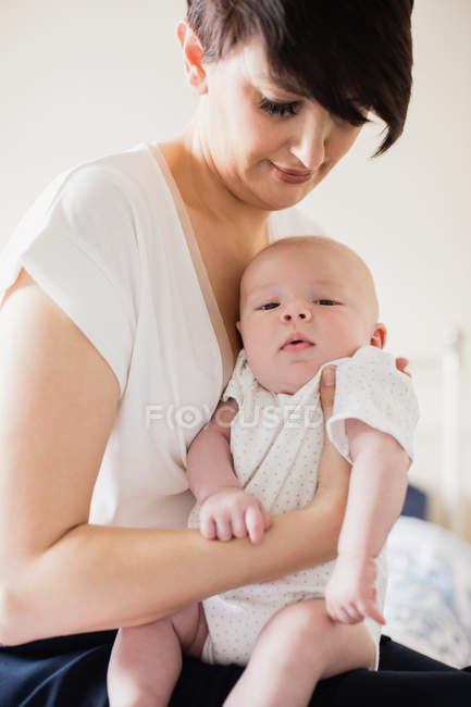 Mutter hält ihr Baby zu Hause — Stockfoto
