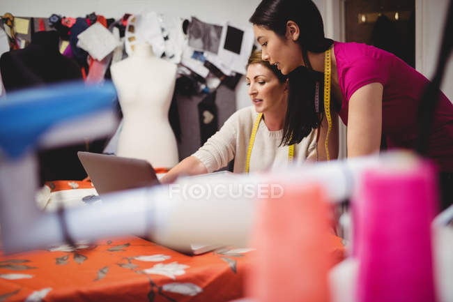 Дизайнери жіночої моди працюють на ноутбуці в студії — стокове фото