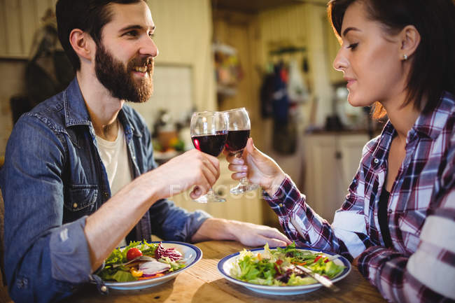 Couple toasting glasses of wine at home — Stock Photo