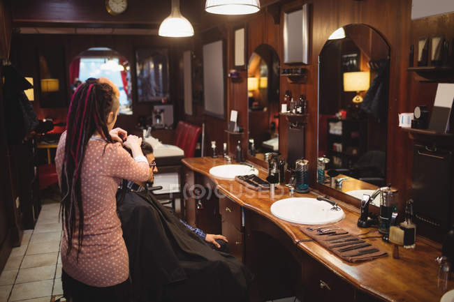 Man getting his hair trimmed in barber shop — Stock Photo