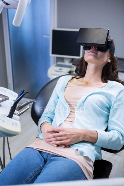Frau benutzt Virtual-Reality-Headset während eines Zahnarztbesuchs in der Klinik — Stockfoto