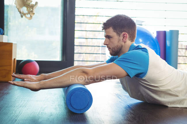 Vista laterale dell'uomo che esegue esercizio di stretching in clinica — Foto stock