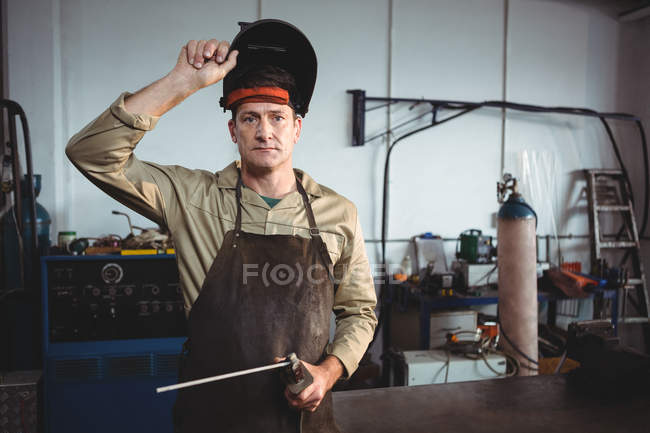 Porträt Schweißer hält Schweißgerät in der Werkstatt — Stockfoto