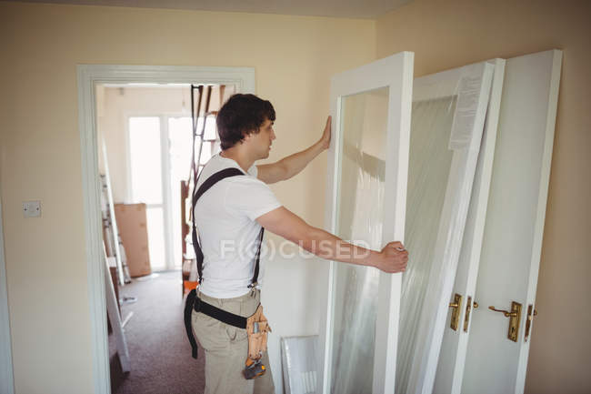 Carpintero trabajando en el marco de la puerta en casa - foto de stock