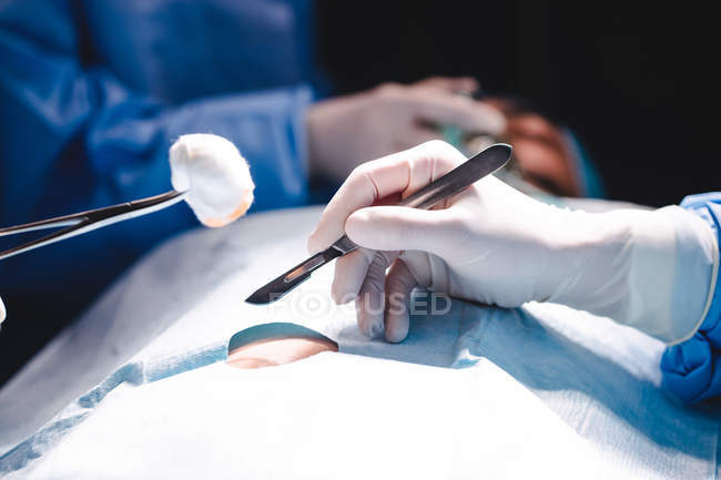 Mãos de cirurgiões que realizam operação em sala de operação no hospital — Fotografia de Stock