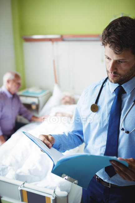 Doctor checking a report in hospital ward — Stock Photo