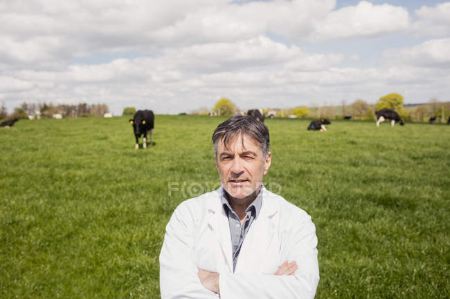 Retrato de veterinário em pé no campo gramado contra o céu nublado — Fotografia de Stock