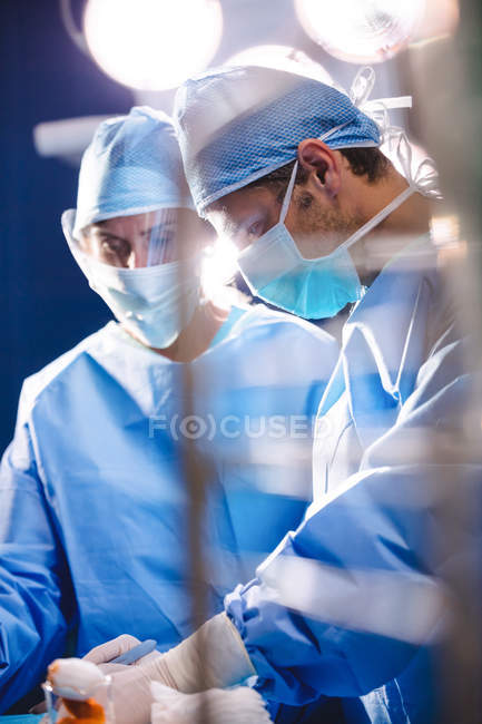 Cirujanos realizando operación en quirófano en el hospital - foto de stock