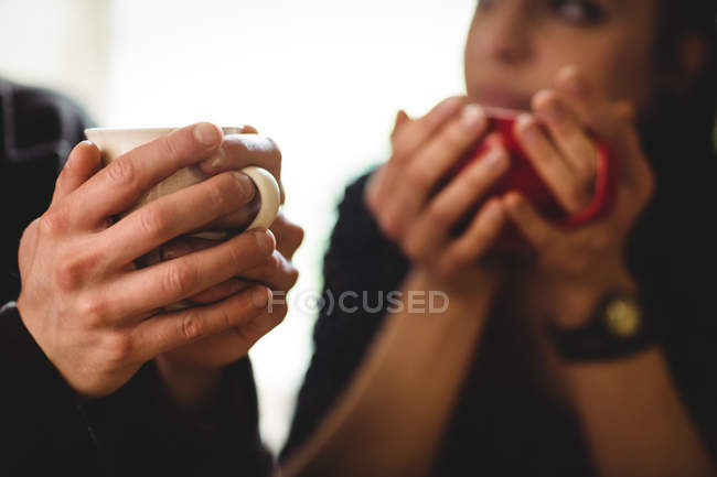 Cropped image of couple having coffee at home — Stock Photo
