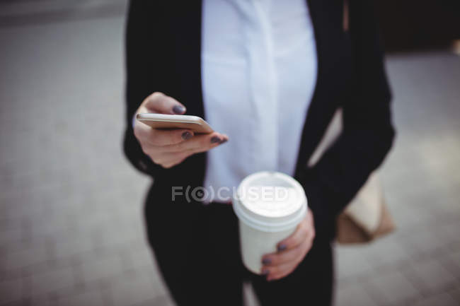 Midsection бизнесвумен с помощью мобильного телефона — стоковое фото