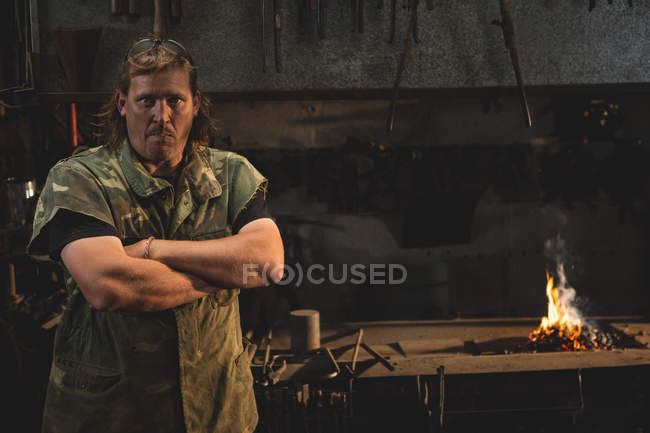 Retrato de ferreiro com braços cruzados na oficina — Fotografia de Stock